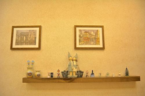 a shelf with figurines on a wall with two pictures at Austria Luxury Apartments, Faraya Hotel in Fārayyā