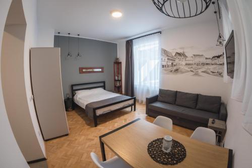 una sala de estar con una cama y una mesa en Zinne Apartments, en Brasov