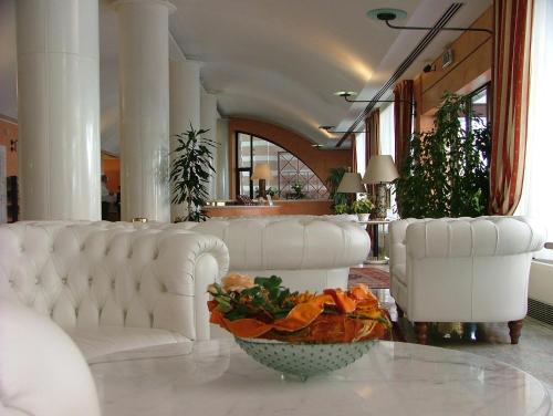 a lobby with white couches and a bowl on a table at Hotel Giberti & Spa in Verona