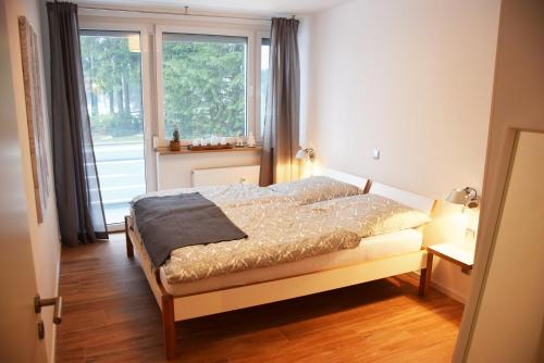 um quarto com uma cama e uma grande janela em FeWo Käppchen Winterberg em Winterberg