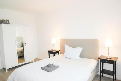 ペーネミュンデにあるSunny Apartment IIのベッドルーム(白いベッド1台、鏡付)