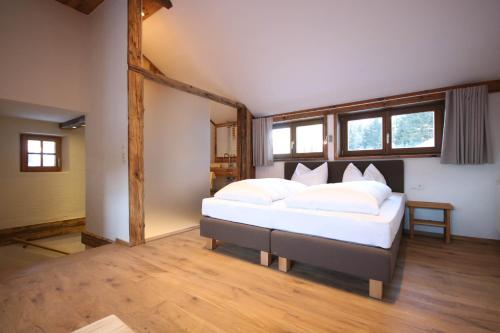 1 dormitorio con 1 cama grande con almohadas blancas en Appartementhaus Brunnenhof, en Wagrain