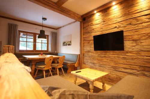 a living room with a wooden wall with a flat screen tv at Appartementhaus Brunnenhof in Wagrain