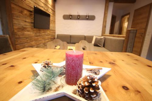 a red candle sitting on top of a wooden table at Appartementhaus Brunnenhof in Wagrain