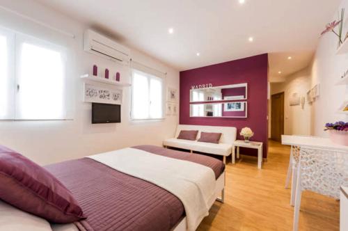 a bedroom with a large bed and a living room at Apartamento en Calle Jardines - Madrid Centro in Madrid