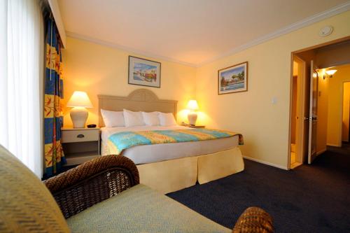Habitación de hotel con cama y silla en Bay View Suites Paradise Island, en Nassau
