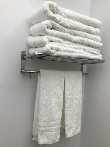 a stack of towels on a towel rack in a bathroom at Destino Deluxe Adama Cáceres in Cáceres