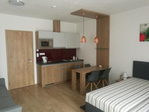 sypialnia z łóżkiem i kuchnia ze stołem w obiekcie Apartmány Sport Dolní Morava w mieście Dolní Morava