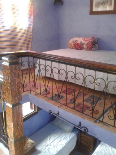 a bedroom with a bunk bed and a staircase at Dar Lbakal in Chefchaouene