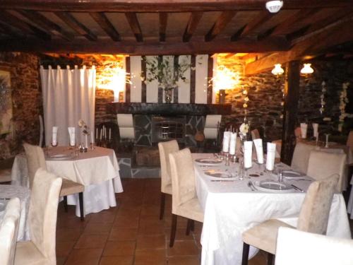 une salle à manger avec tables et chaises et une cheminée dans l'établissement Hotel Ermitage du Moulin Labotte, à Haybes