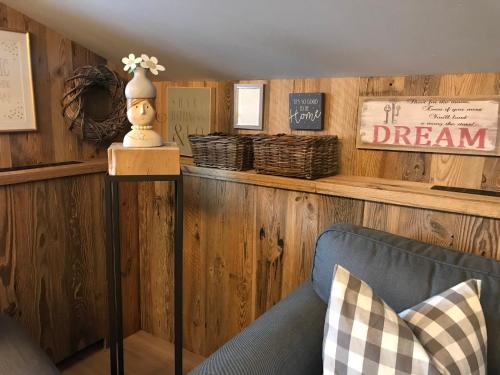 a living room with wooden walls and a blue couch at Gästehaus Weiherhof in Alpbach