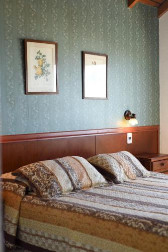 a bedroom with a bed and two pictures on the wall at Hostería Mar de Ajó in Mar de Ajó