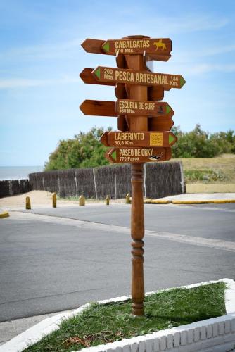 un poste con letreros de la calle a un lado de una carretera en Hostería Mar de Ajó, en Mar de Ajó