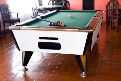 a pool table with a cue and a ball on it at Hostería Mar de Ajó in Mar de Ajó