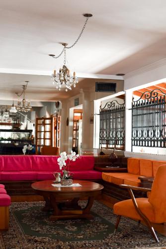 a living room with a red couch and a table at Hostería Mar de Ajó in Mar de Ajó