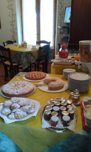 una mesa con muchos tipos diferentes de comida en ella en B&B La Piaggia, en Montemerano
