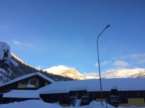 a building covered in snow with a street light at Hotel Cà Fiore in Bardonecchia
