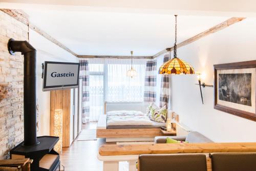 a living room with a fireplace and a bed at Achen Appartement in Bad Hofgastein