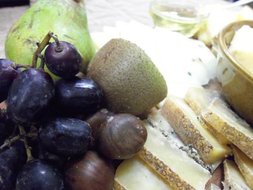 a plate of food with grapes and other foods at Agriturismo la Sforzata in Collegno