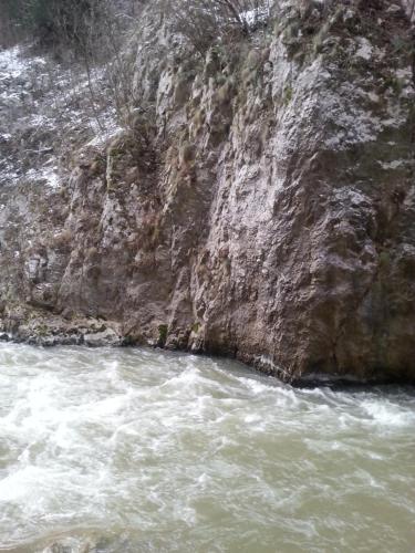 a river next to a rocky cliff with white water at Golemi kamik Pirot in Pirot