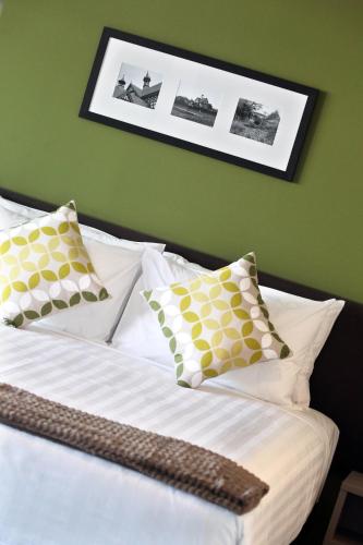 a bedroom with a bed with white sheets and pillows at Quest Rotorua Central in Rotorua