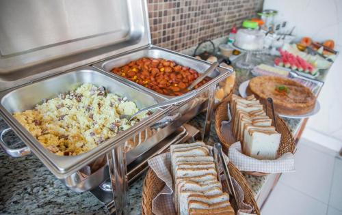 un buffet con molti tipi diversi di cibo su un bancone di Pousada Manhã Dourada a Arraial d'Ajuda