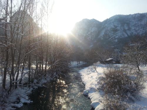 a river covered in snow with the sun in the background at Golemi kamik Pirot in Pirot