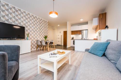 a living room with a couch and a table at Apartamenty Tespis - Francuska Atal Park in Katowice