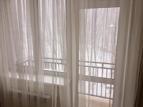 a window with white curtains in a room at Polyana Apart in Polyana