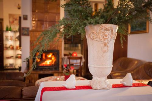 a white vase sitting on top of a table at Gościniec i Herbaciarnia Pod Złotą Łyżwą in Białka Tatrzanska
