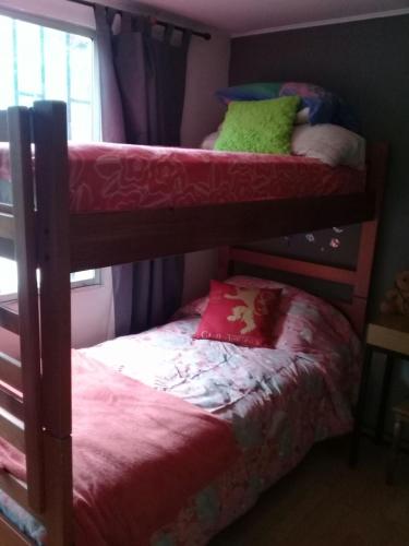 a bedroom with two bunk beds and a window at Parcela 9 Nehuen in Talagante