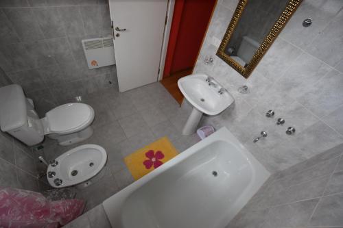 烏斯懷亞的住宿－愛戀旅館，浴室配有盥洗盆、卫生间和浴缸。