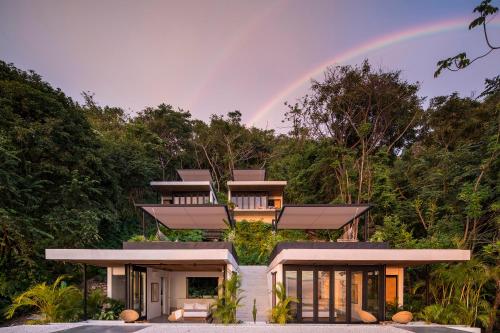 a rainbow in the sky above a house at Mint Santa Teresa - Adults only in Santa Teresa Beach