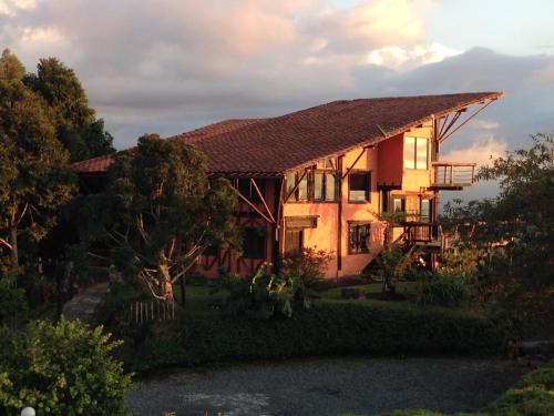 a house with a sunset in the background at Santa Elena de la Colina in Filandia
