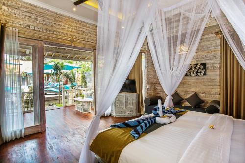 a bedroom with a bed with curtains and a fireplace at The Palm Grove Villas in Nusa Lembongan