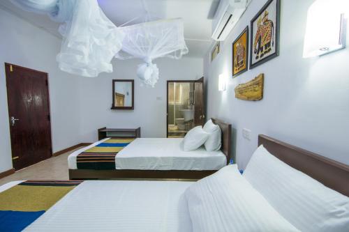 a hotel room with two beds and a mirror at Udawatta Kele (UK) Forest Lodge in Kandy