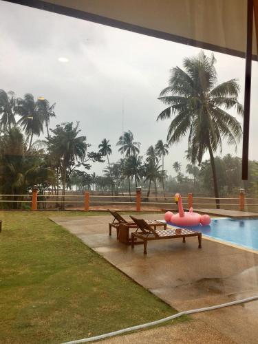 a pool with a pink inflatable flamingo on a bench at Sleep Soundly By The Sea in Trat