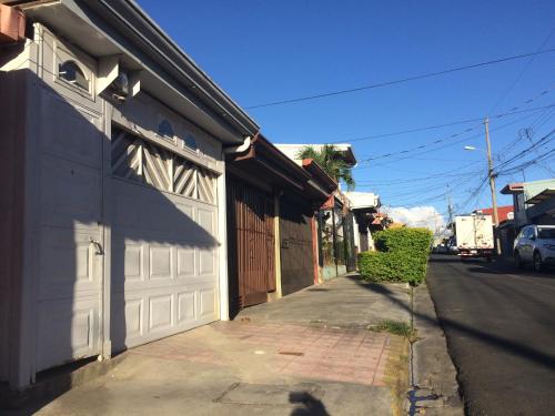 a white garage door on a house on a street at Guesthouse Casa Lapa in Alajuela City