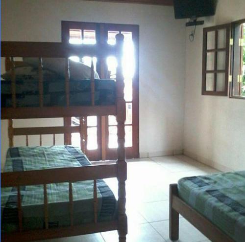 two bunk beds in a room with a window at Jambeiro na praia in Trindade