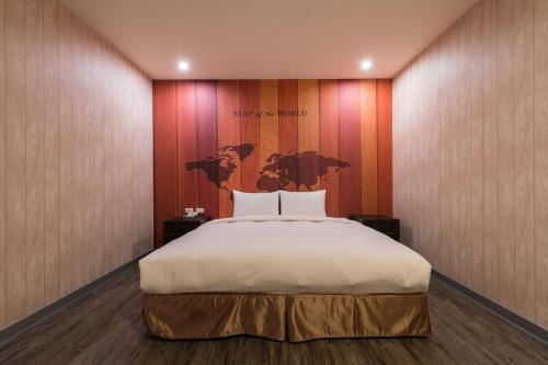 a bedroom with a bed with a map on the wall at Skyone Hotel in Kaohsiung