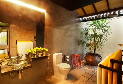 a bathroom with a toilet and a sink and a plant at Dickman Resort "The Boutique Hotel" in Negombo
