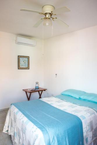 a bedroom with a bed and a ceiling fan at Casa Loritos in Cancún