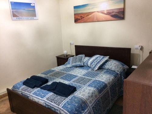 1 dormitorio con 1 cama con 2 almohadas azules en Bounty Bedroom en Puerto del Rosario