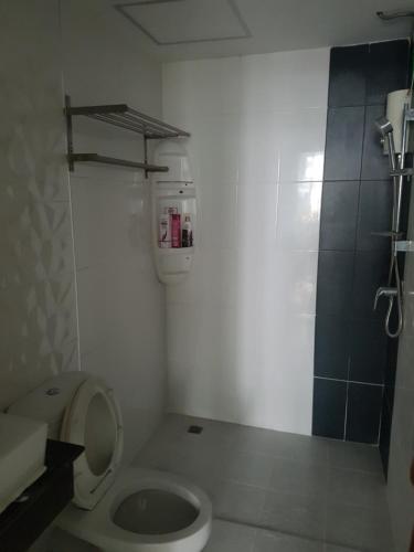 La petite salle de bains est pourvue d'une douche et de toilettes. dans l'établissement The Idol Bangsaen 206, à Bang Saen