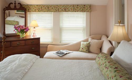 a bedroom with a bed and a chair and a mirror at Sugar Hill Inn in Sugar Hill
