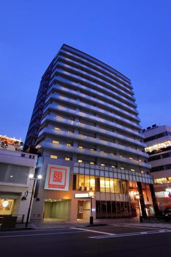 a tall building with windows in a city at night at Kobe Motomachi Tokyu REI Hotel in Kobe