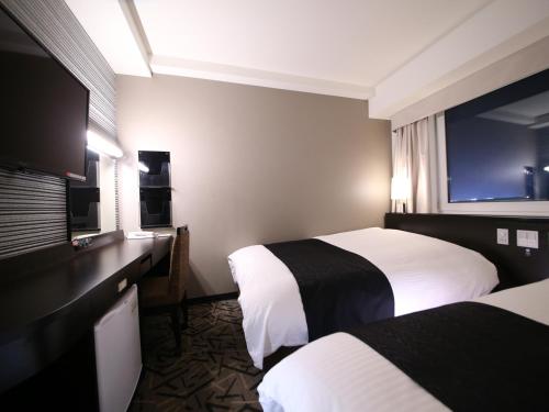 a hotel room with two beds and a window at APA Hotel & Resort Tokyo Bay Makuhari in Chiba