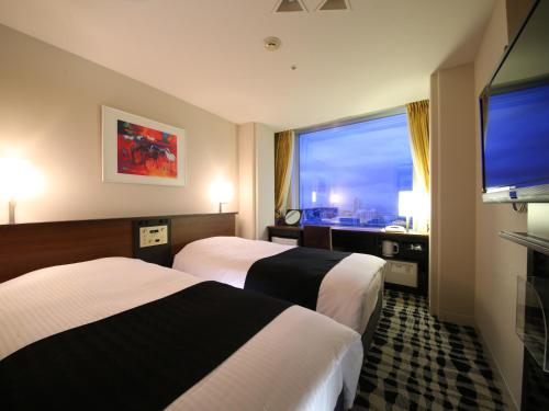 a hotel room with two beds and a large window at APA Hotel & Resort Tokyo Bay Makuhari in Chiba