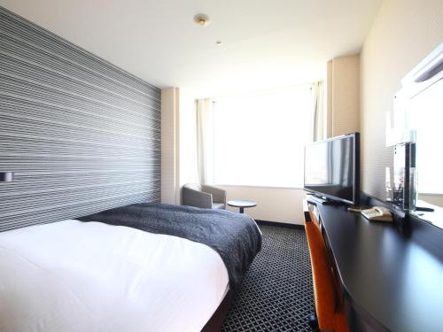 a hotel room with a bed and a flat screen tv at APA Hotel & Resort Tokyo Bay Makuhari in Chiba