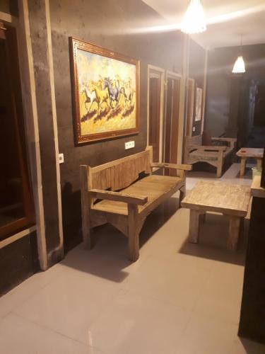 a room with two benches and a painting on the wall at New Ubud Hostel in Ubud